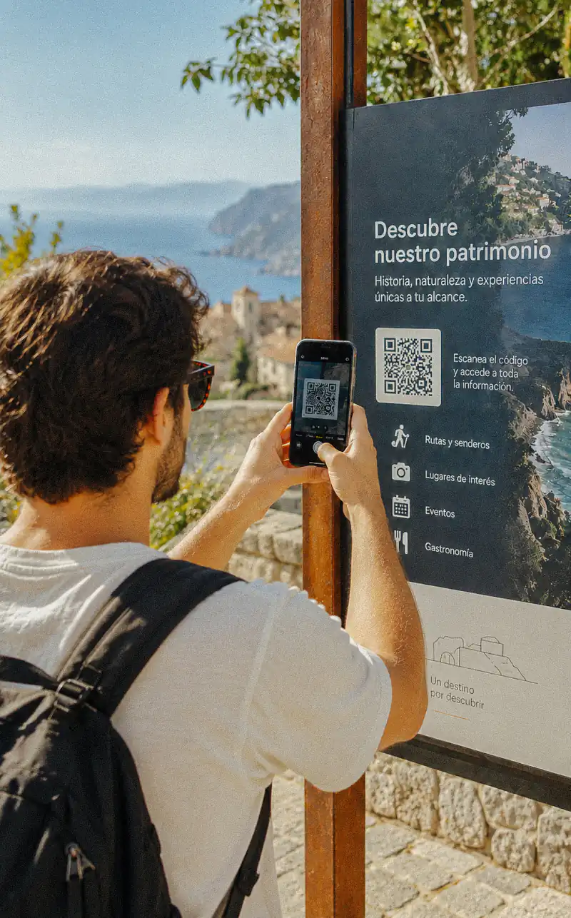 Visitante escaneando un código QR de un cartel turístico para abrir la audioguía del punto de interés